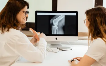 Dr. Kathrin Hanswille erklärt einer Patientin den Aufbau des Kniegelenks anhand einer Röntgenaufnahme und eines Kniemodells