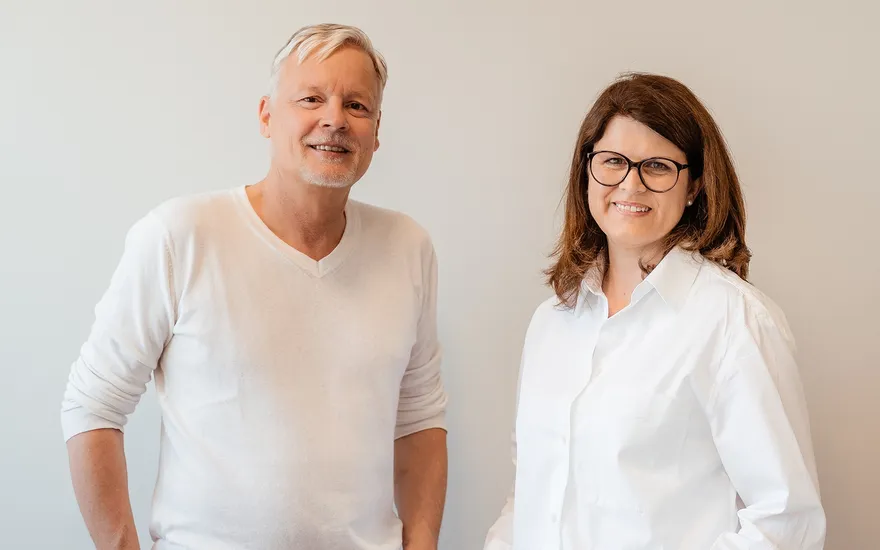 Dr. Burkhard Schubert und Dr. Kathrin Hanswille mit weißer Kleidung in der Praxis