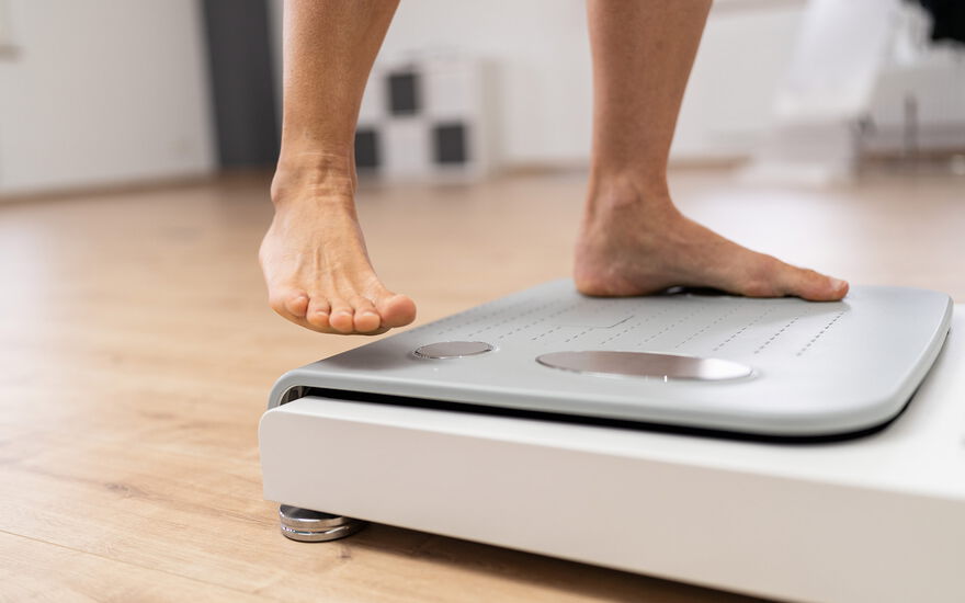 Nackte Füße eines Manns beim Betreten einer Bioimpedanz Waage