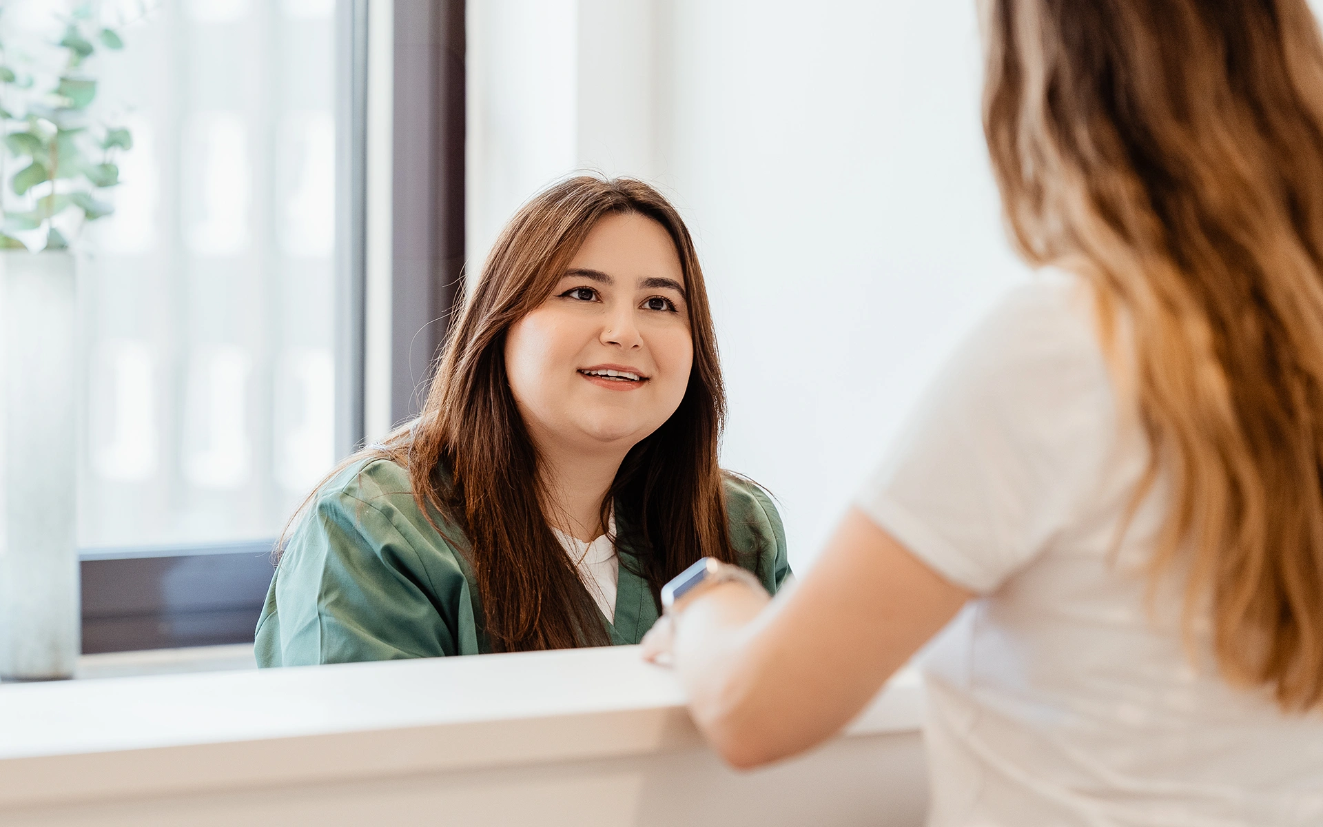 Patientin beim Gespräch am Empfang